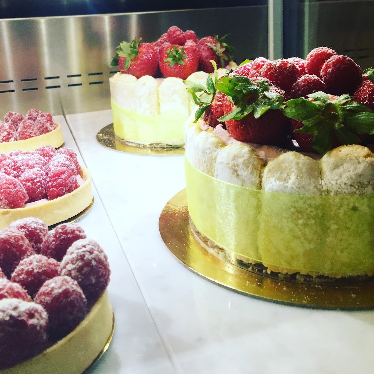 Whole cakes and raspberry tarts in the Savour Bakery cake case