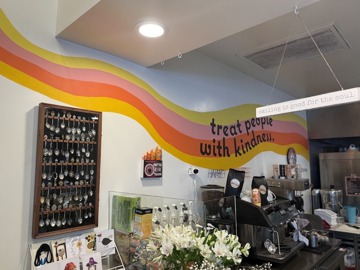Inside Savour Bakery, with a painted rainbow mural reading treat people with kindness